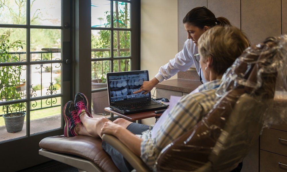 Dr. Lynch reviewing an x-ray on a laptop with a patient in the Scottsdale office